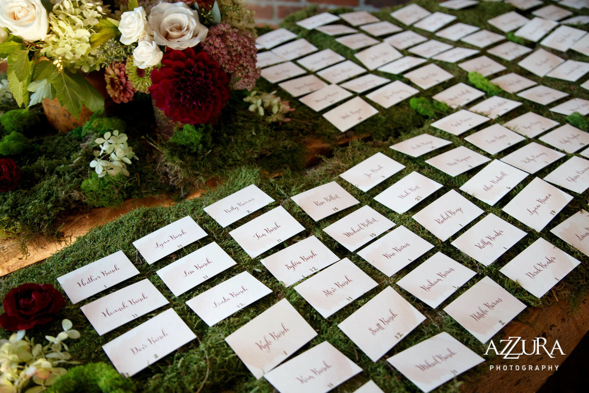 escort cards on a bed of moss with fall flowers