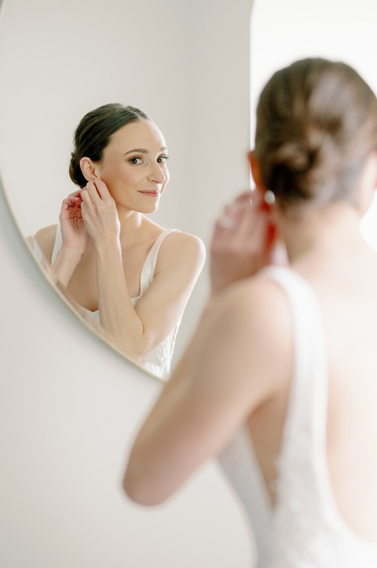 a bride putting on earrings