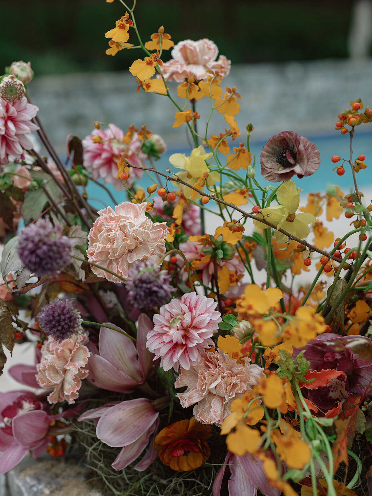 Sculptural ikebana and meadow arrangements decorate the cocktail hour for private estate wedding in Tennessee hills.Clear top tent build out for fall wedding reception in Tennessee hills.  Trailing bar arrangements and floral meadow centerpieces for autumnal wedding reception. Orchids, bittersweet berries, butterfly ranunculus, and tulips are highlighted. Artistic fall color palette in copper, gold, ruby, lavender, and rust. Design by Rosemary & Finch Floral Design in Nashville, TN.