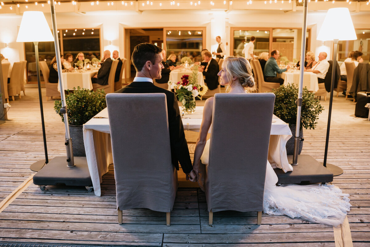 Bride and groom seated at head table during dinner