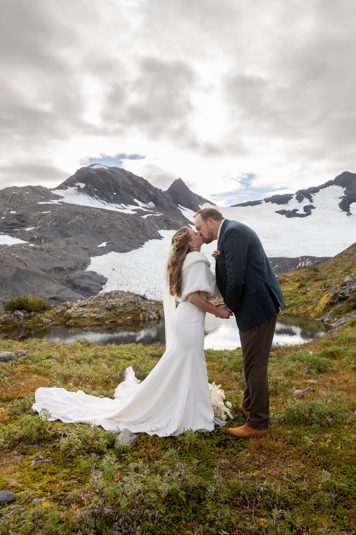 A bride and groom share their first kiss after their Alaska elopement ceremony.