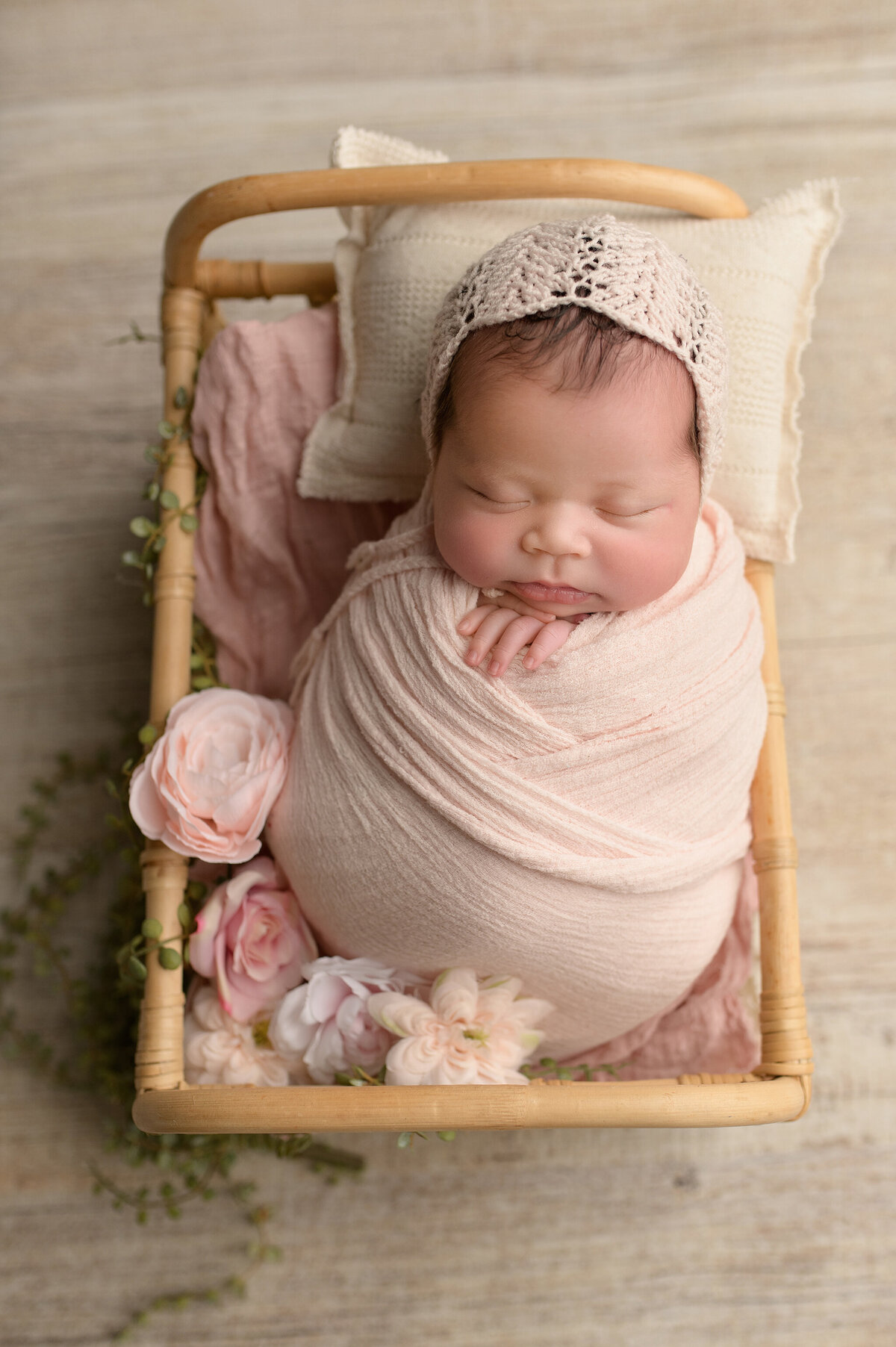 Newborn baby in pink swaddle