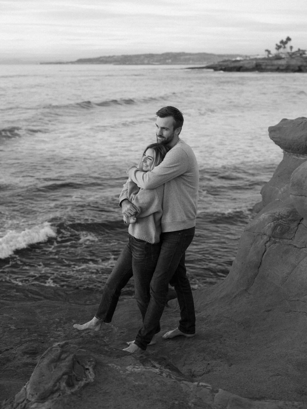 Beautiful Sunset Cliffs engagement photo of the couple on a cliffside, perfectly lit by a San Diego wedding photographer in La Jolla.