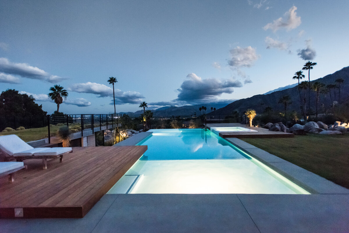 Evening view from house towards infinity edge pool and expansive mountain views designed by Palm Springs architect