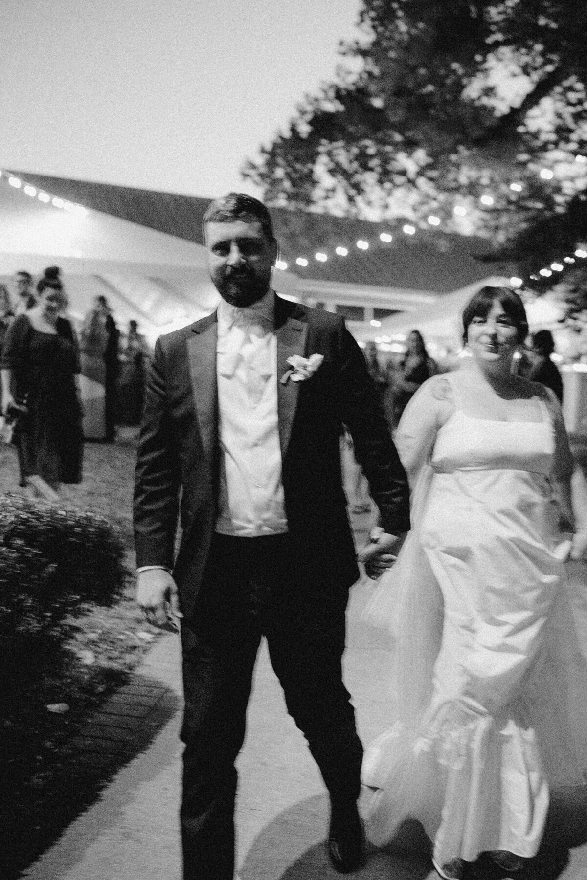 Bride and groom walking outside marquee at wedding reception at Umlauf Sculpture Garden, Austin