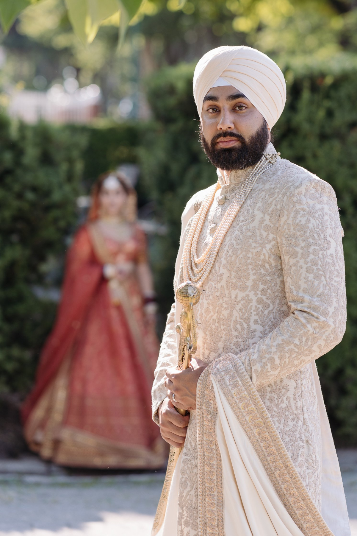 sikh-wedding-outdoor-bride-peach-lehenga-groom-ivory-sherwani-turban-sword
