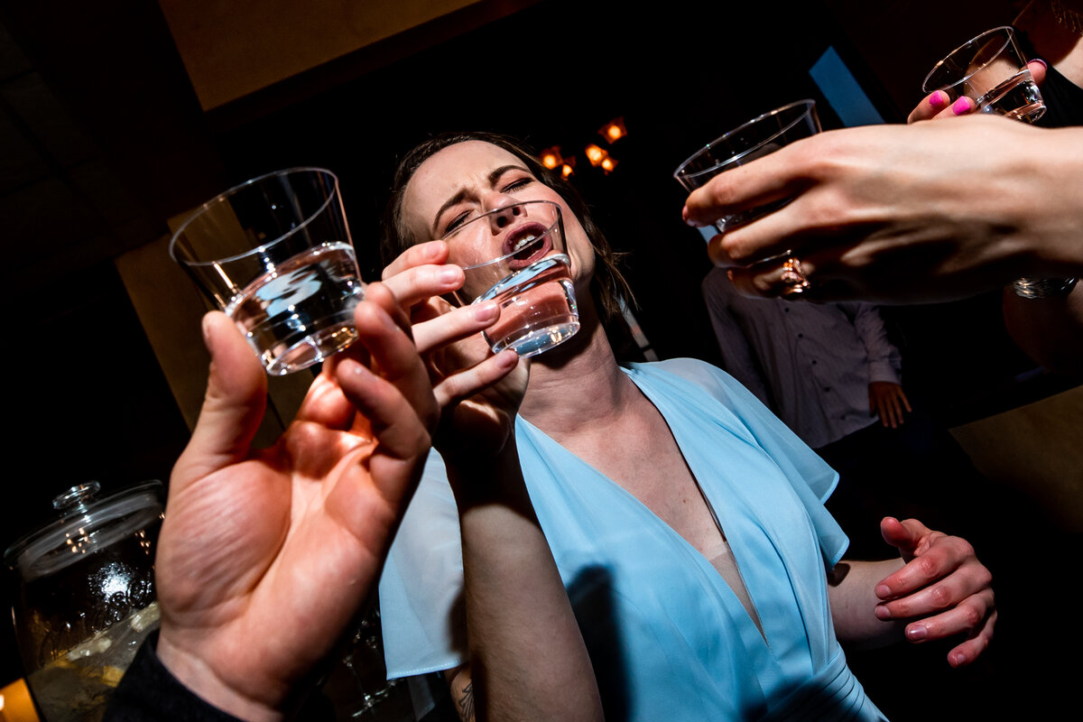 Bridesmaids takes a shot with other guest during wedding reception.