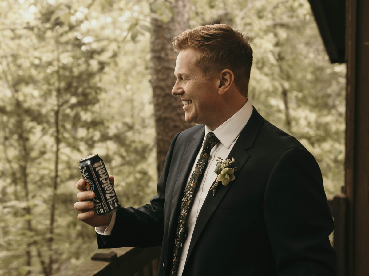groom drinking beer in the woods