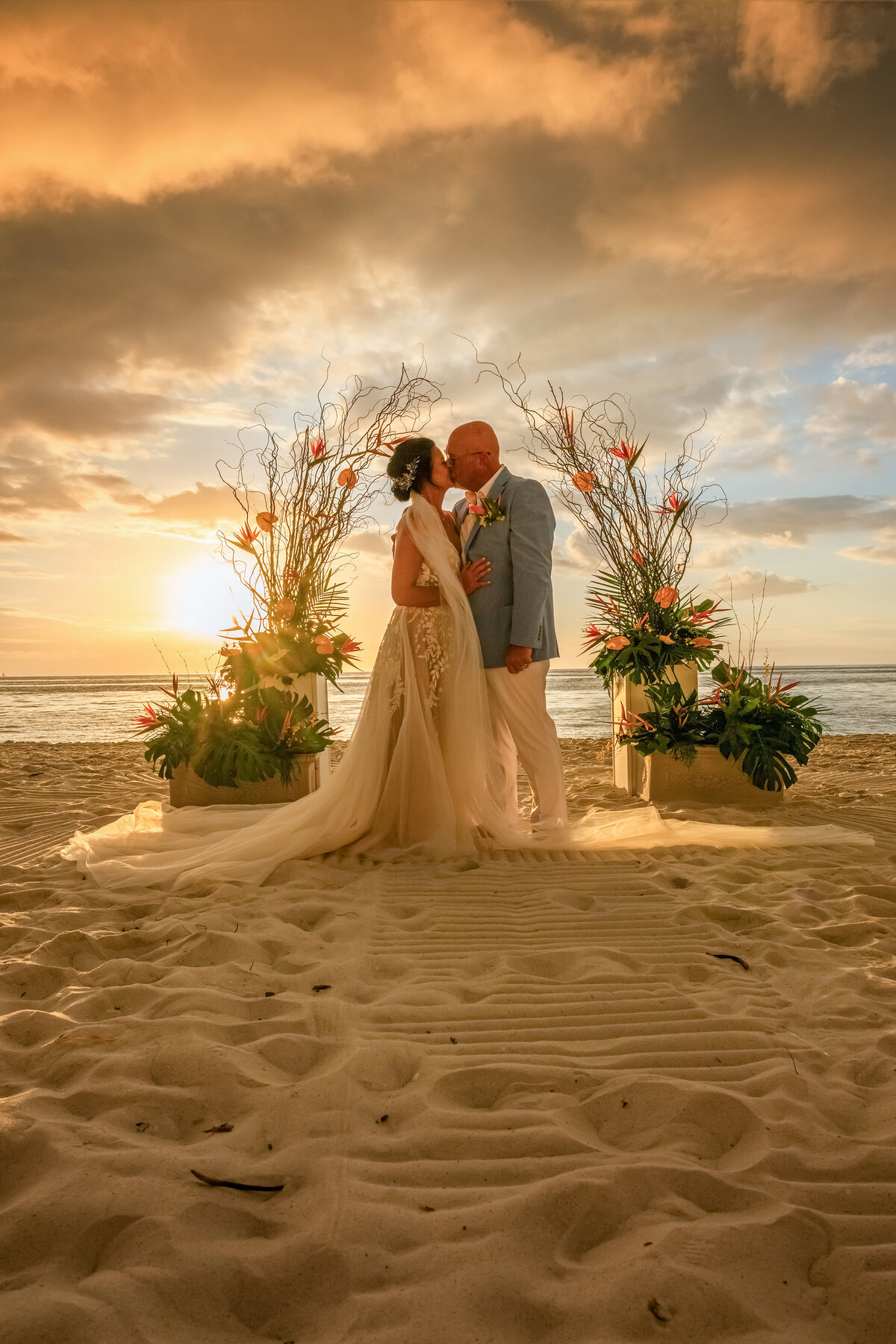 A big rain storm rolls in as Groom and bride are getting married at Edgewater hotel  beach during the sunset .