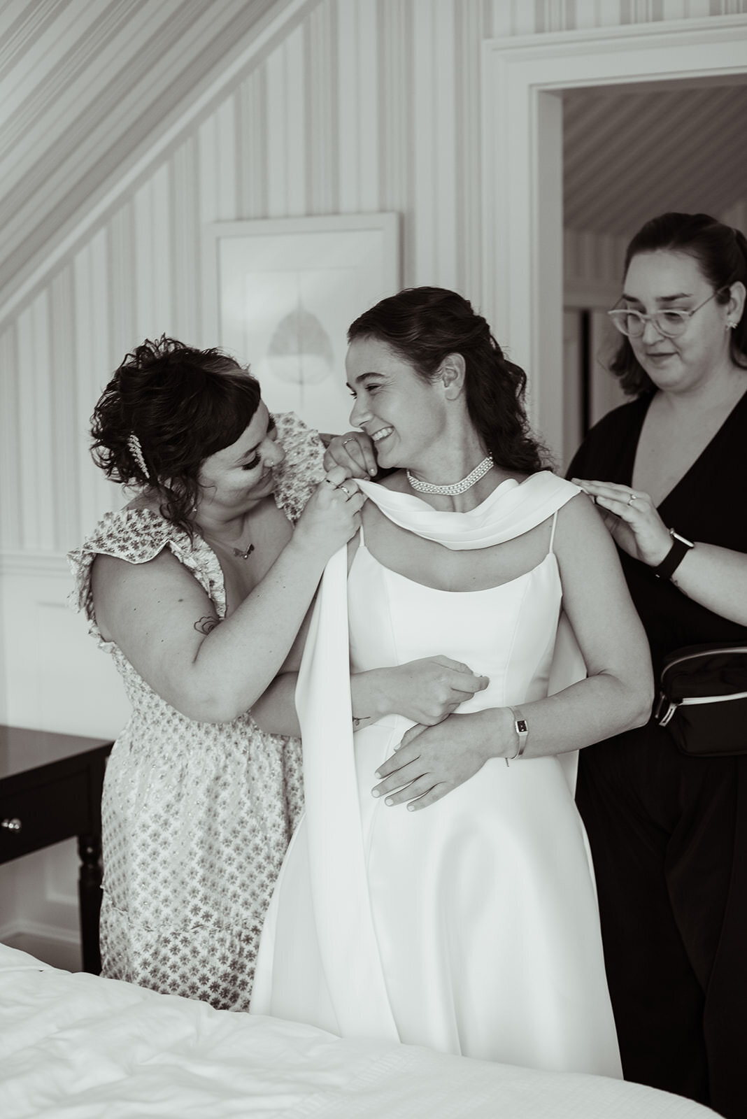 Rachel and other lady helping bride with wedding dress
