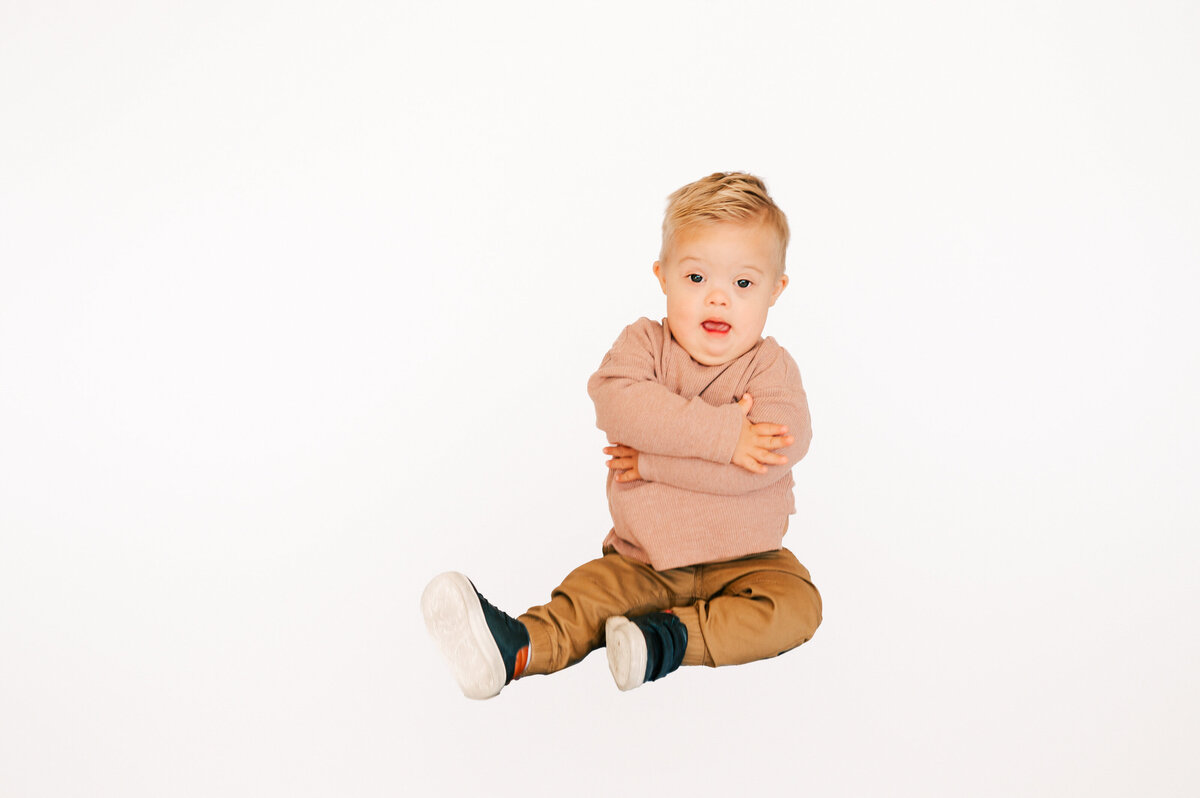 toddler boy giving himself a hug captured by Springfield MO special needs kids photographer Jessica Kennedy of The XO Photography