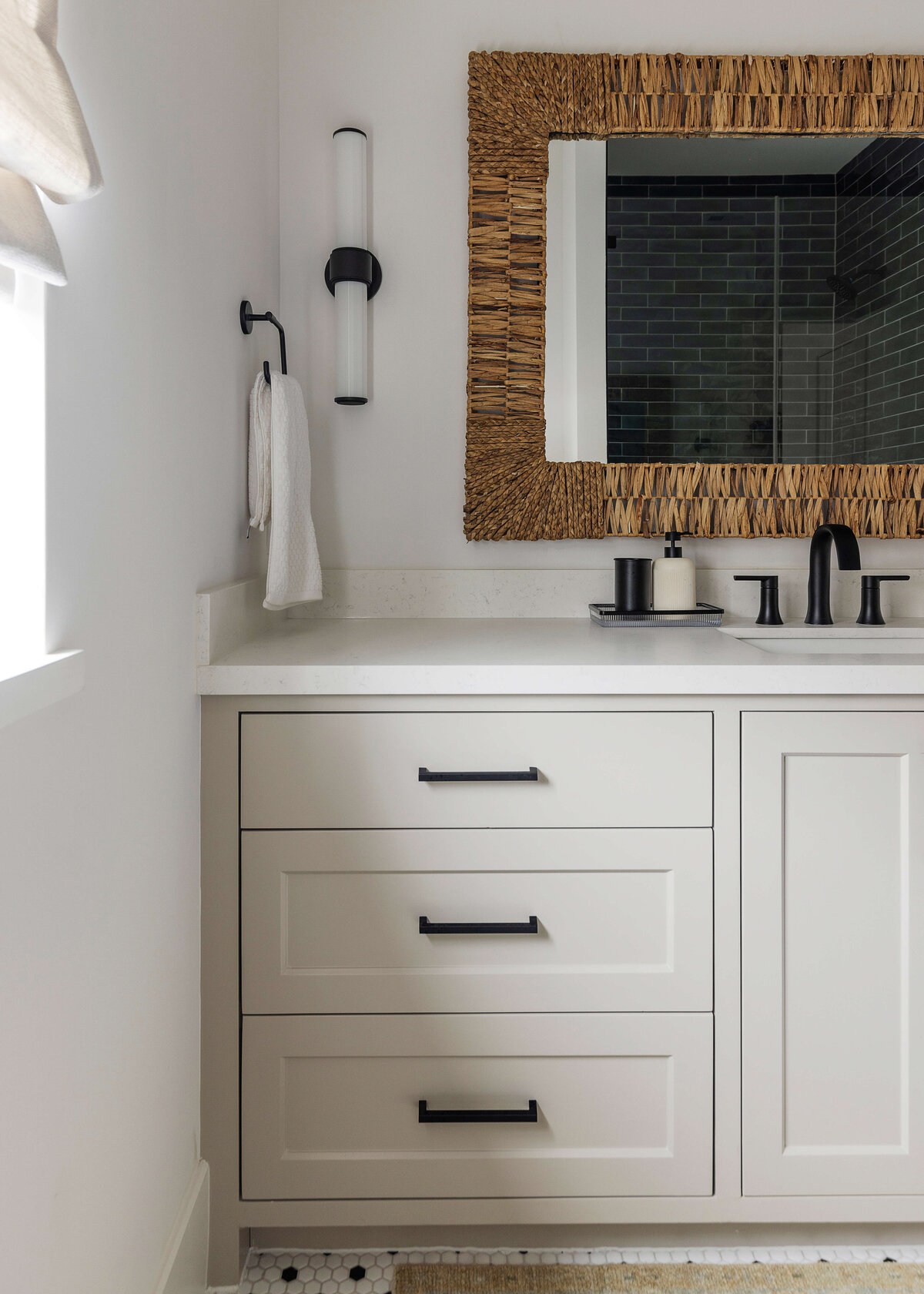 oyster creek studios missouri city new build white bathroom with black hardware and wicker mirror