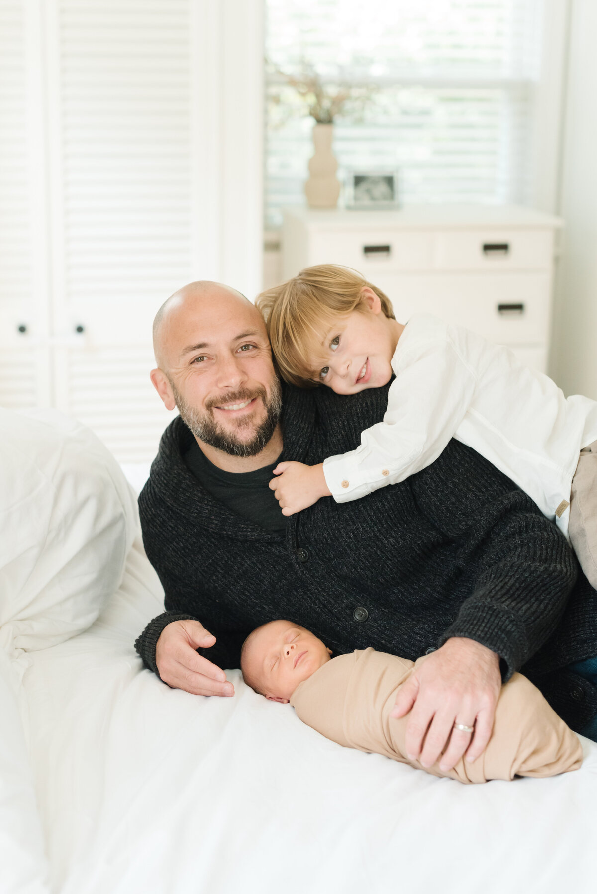 Dad with toddler and newborn on bed - Washington DC Newborn Photographer