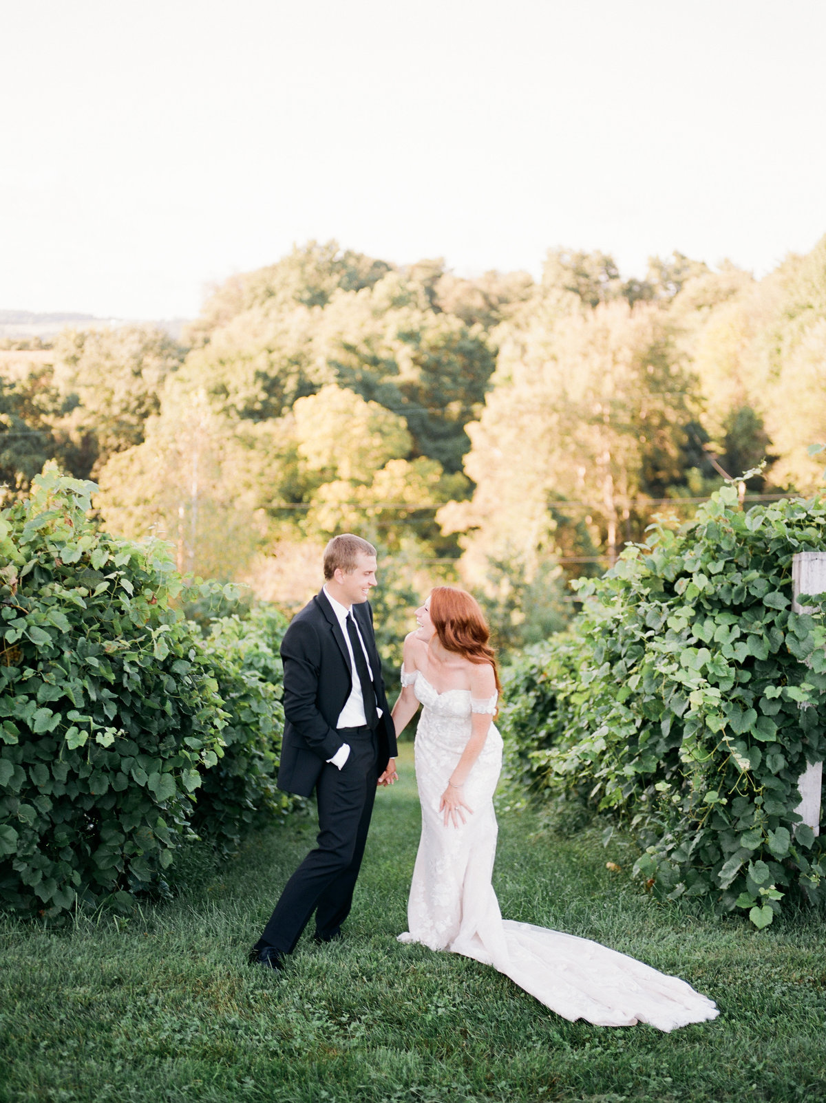 bride and groom laughing by greenery at philadelphia wedding