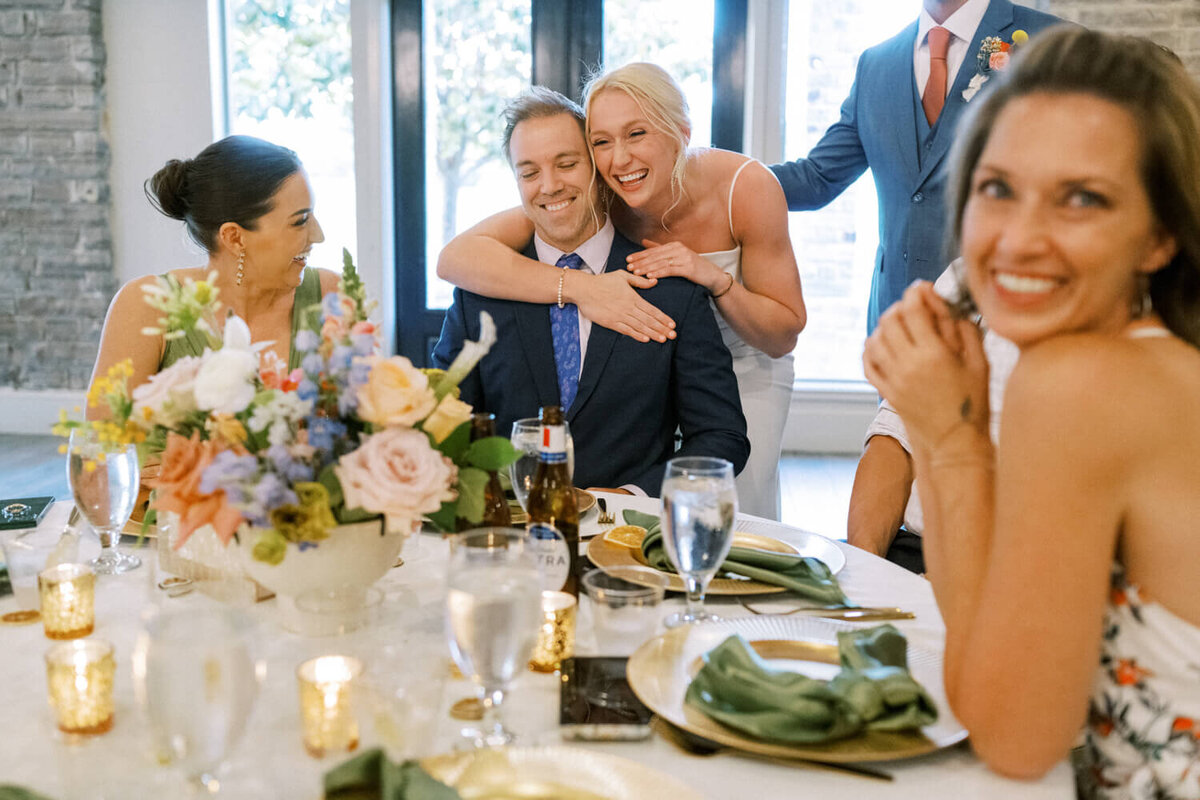 bride-hugging-man-from-behind-while-everyone-laughs