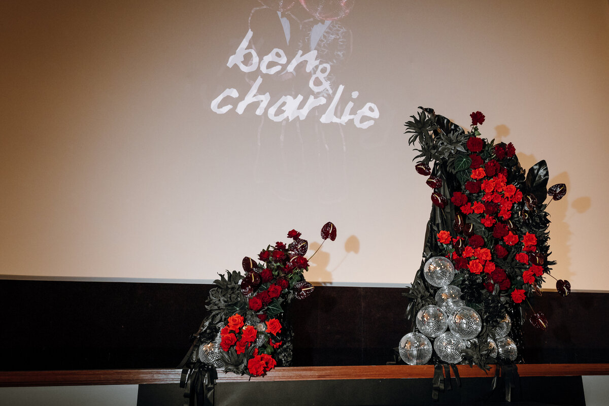 Red floral arrangements for the stage at the Regal Cinema Wedding of Ben & Charlie.