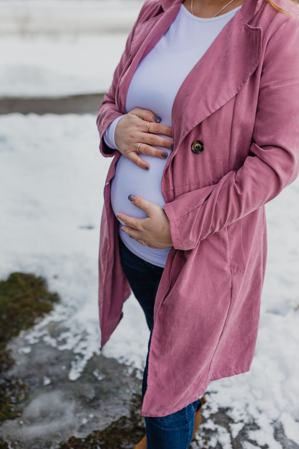 Pregnancy announcement with soon to be mom outside holding belly.