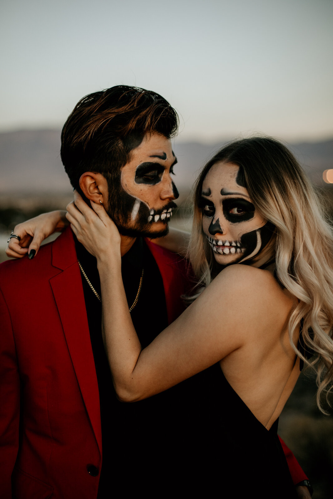 couple wearing skeleton makeup holding each other