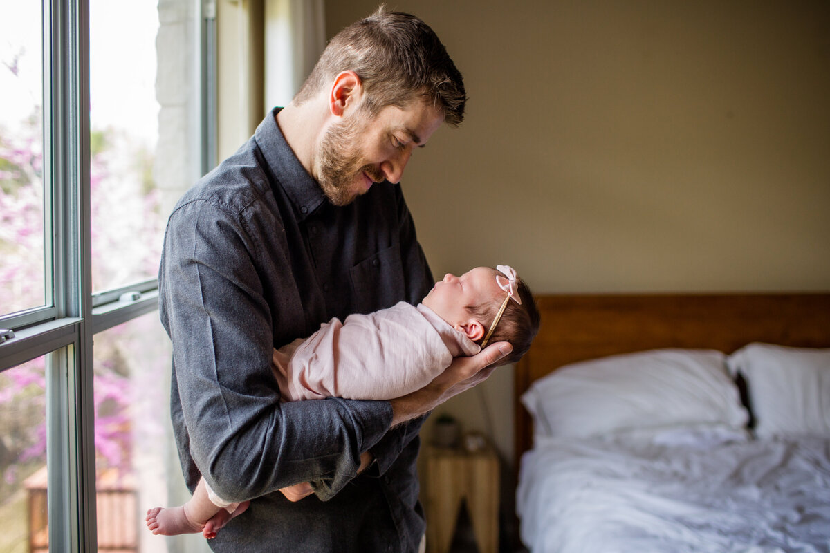 Daddy marvels at his daughter in beautiful natural light.