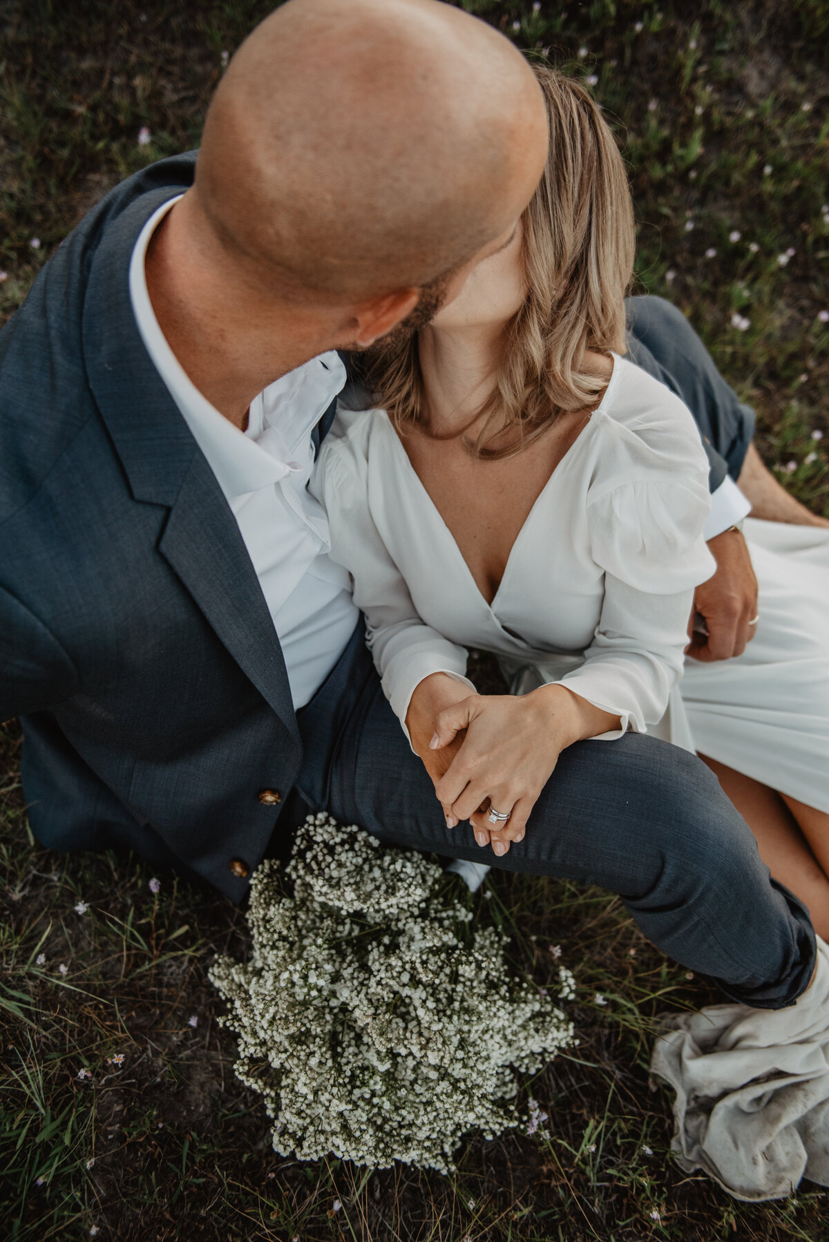 jackson wyoming photographer captures birdseye view of bride and groom sitting in a field and kissing