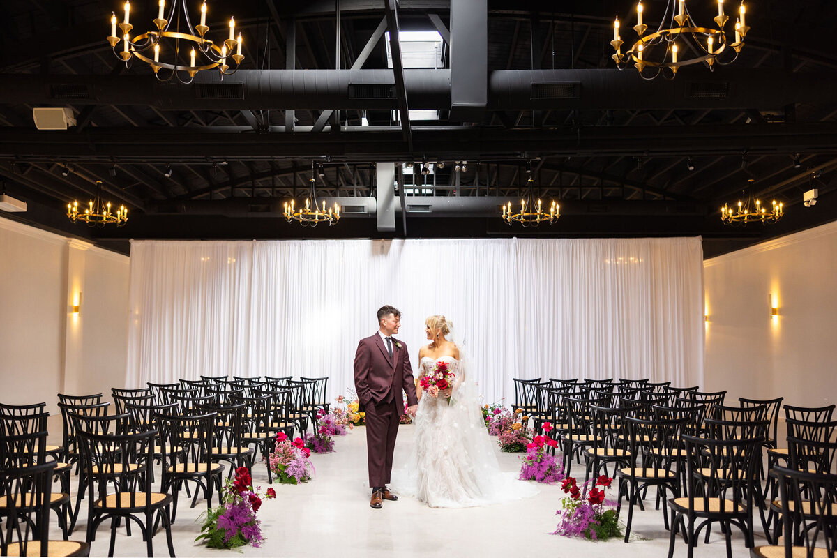 up to 200 guests in Locus for ceremony with draped backdrop and statement ground floral arch piece