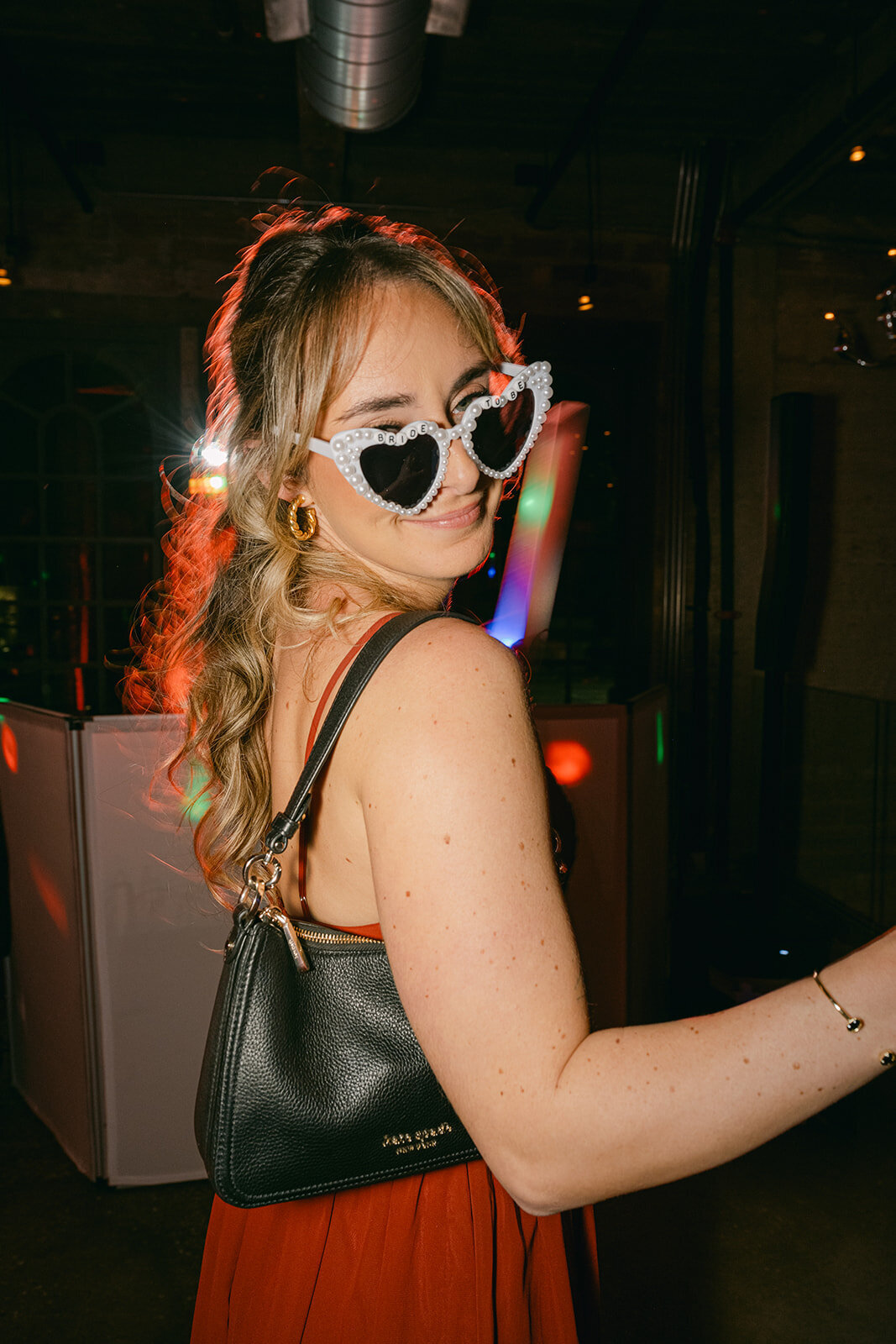 Playful wedding guest in heart-shaped glasses during editorial-style flash wedding after party