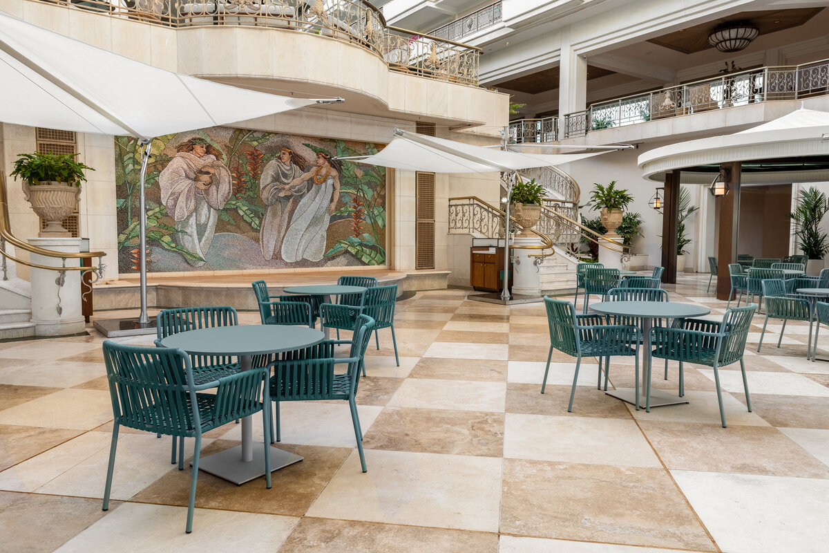 The 'Ikena restaurant's mural and tables at the base of the main atrium.