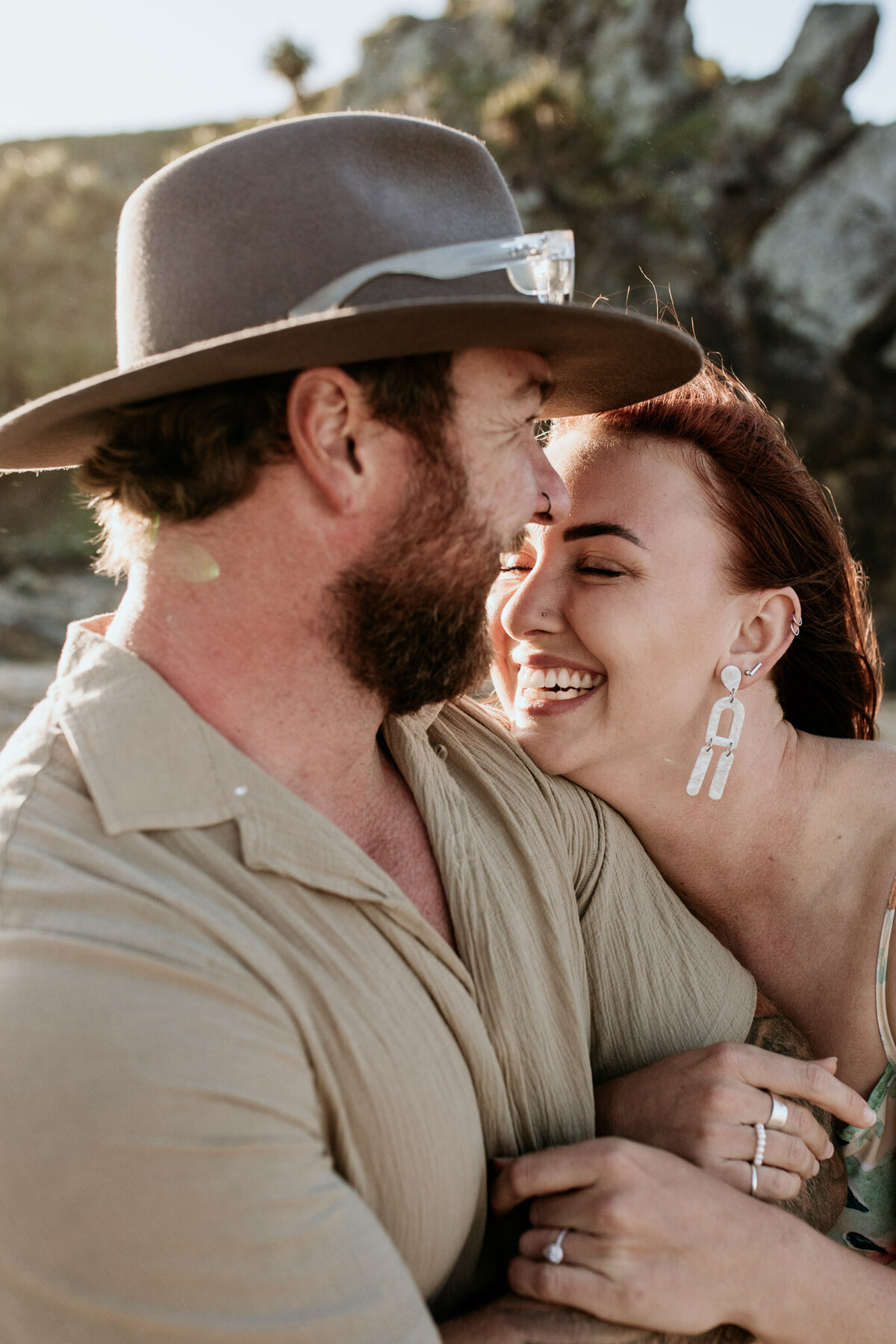 Raw emotion of a couple laughing on the beach with the female closing her eyes, treasuring the moment. Captured by Bendigo Wedding Photographer.