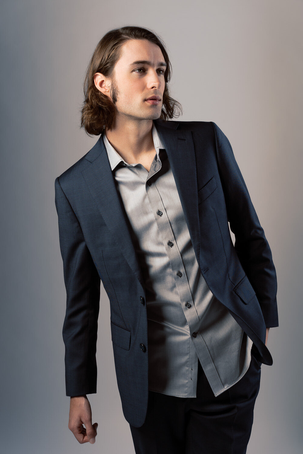 Stylish studio portrait of a man in a tailored suit, leaning casually for a relaxed and confident fashion-inspired look, photographed in Austin, TX.

