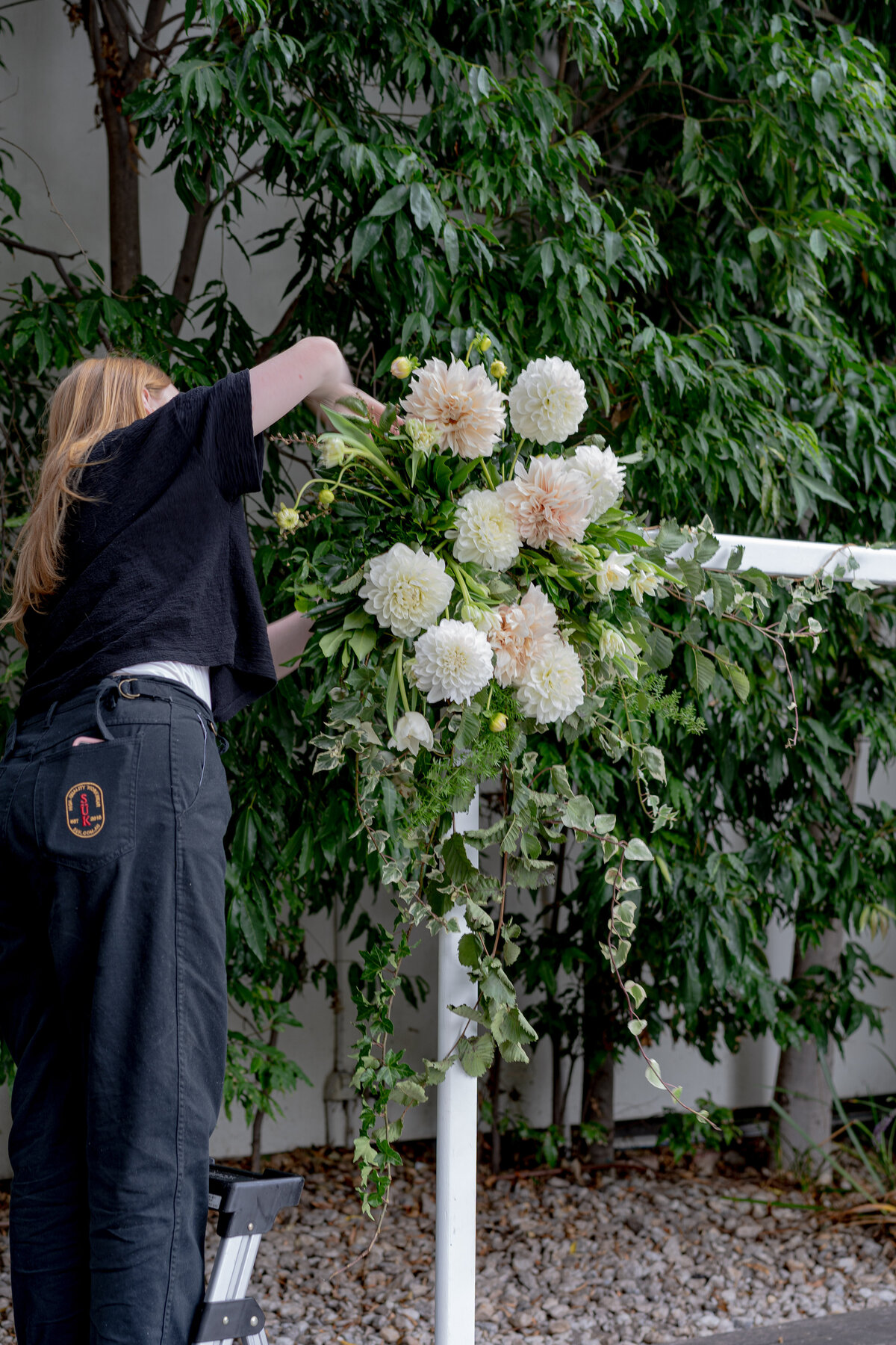An Estúdyo team member installing wedding flowers prior to a Melbourne ceremony
