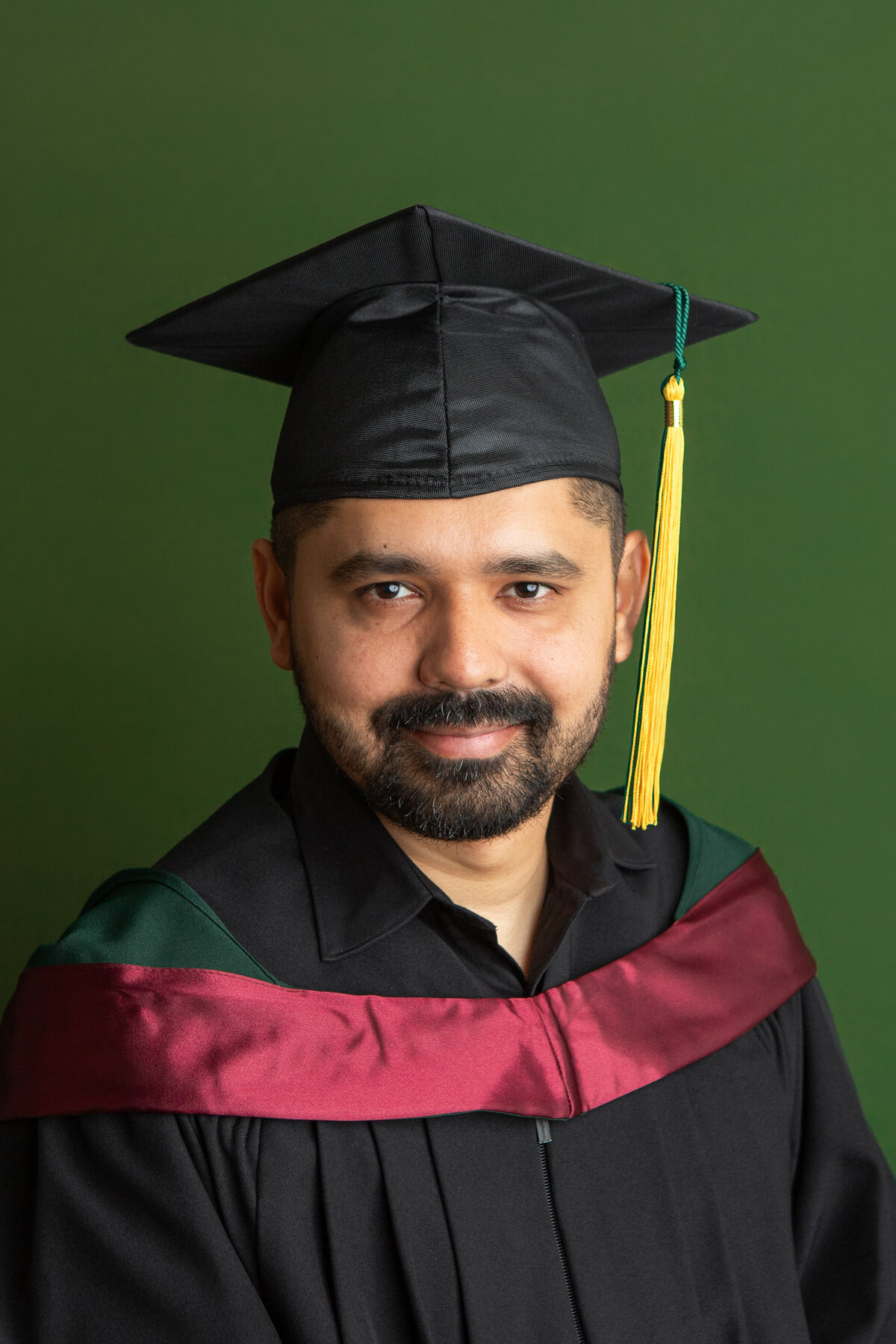 University of Alberta Graduation Headshot Green Backdrop Cap and Gown