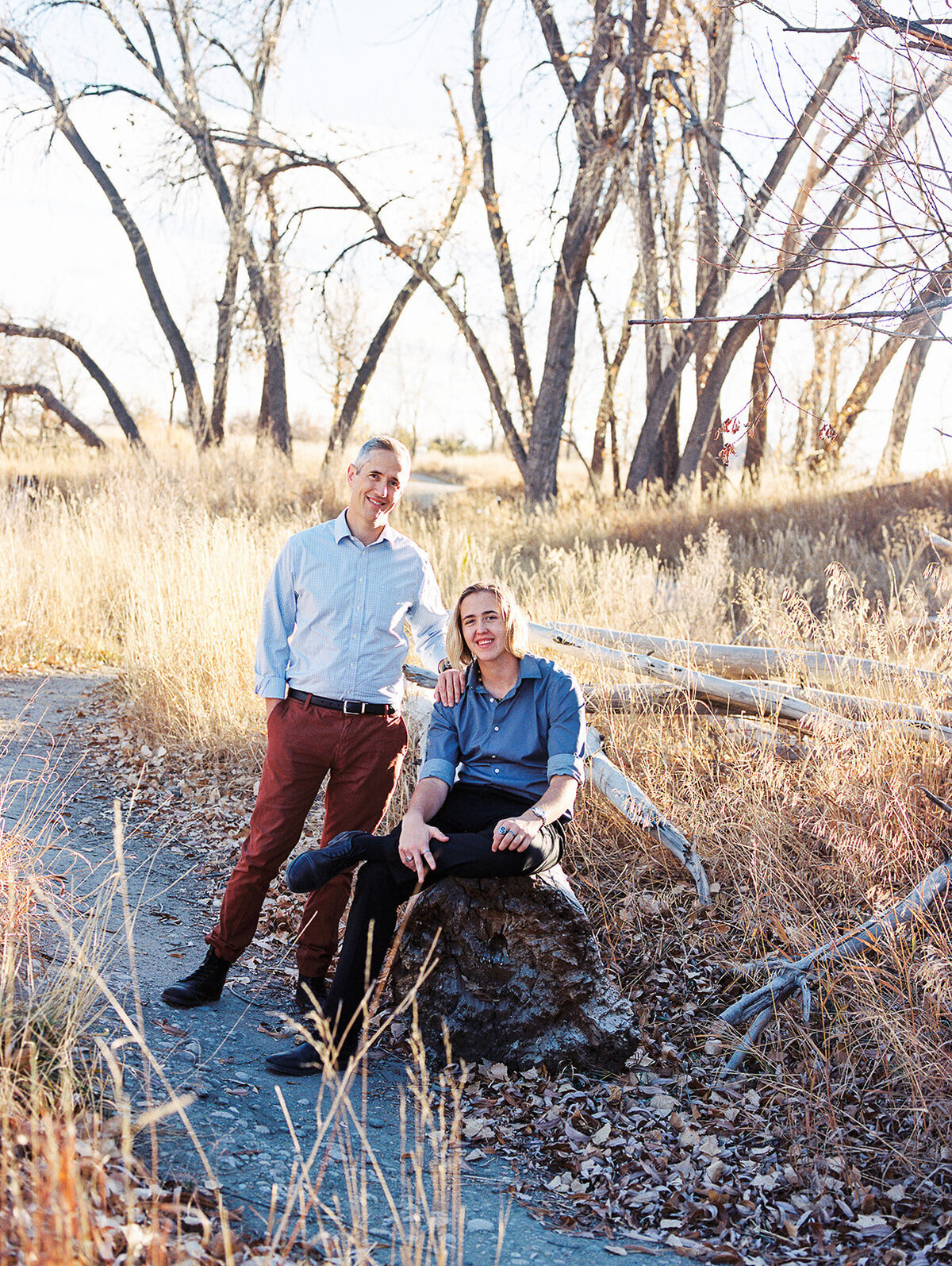 dad and teen child stand in woods for photo on late fall day