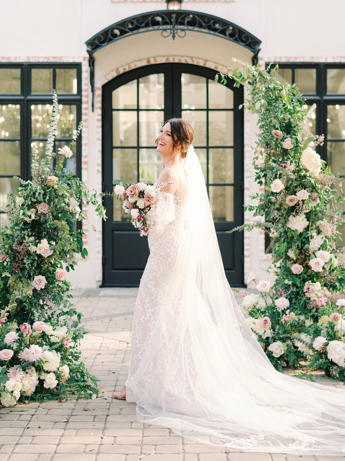 the peach orchard stunning bride in white with pink floral arch