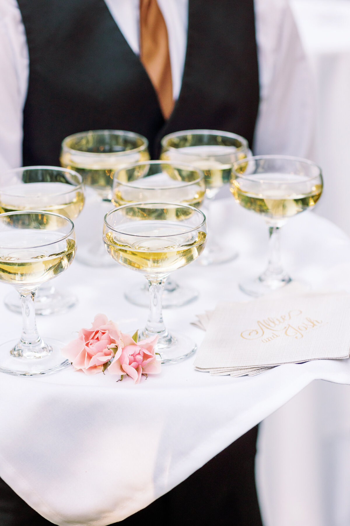 A person holding a platter of champagne