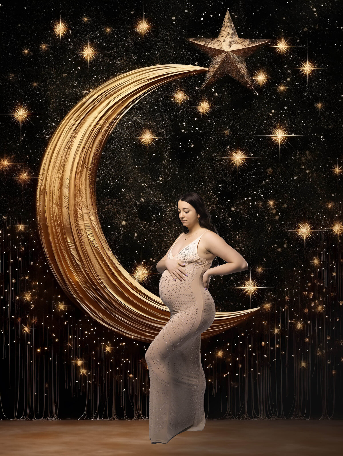 pregnant woman standing in front of crescent moon holding her belly in maternity session with reva davis photography
