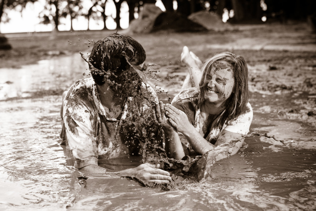 The couple enjoys a good old mudbath during their engagement session in Point Clear, Alabama.