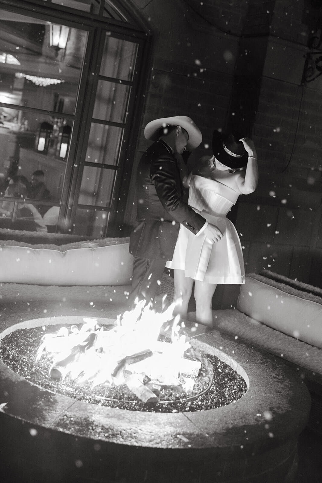 Bride and Groom share an intimate moment in an embrace by the warm fire outside of the St. Regis Aspen wedding venue.