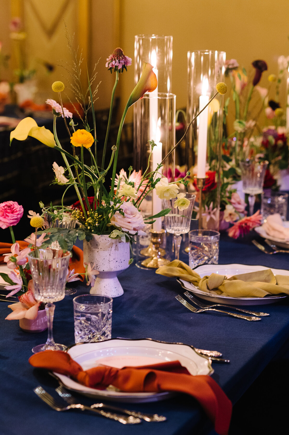 A table at a Rialto wedding reception is decorated with bright floral centrepieces.