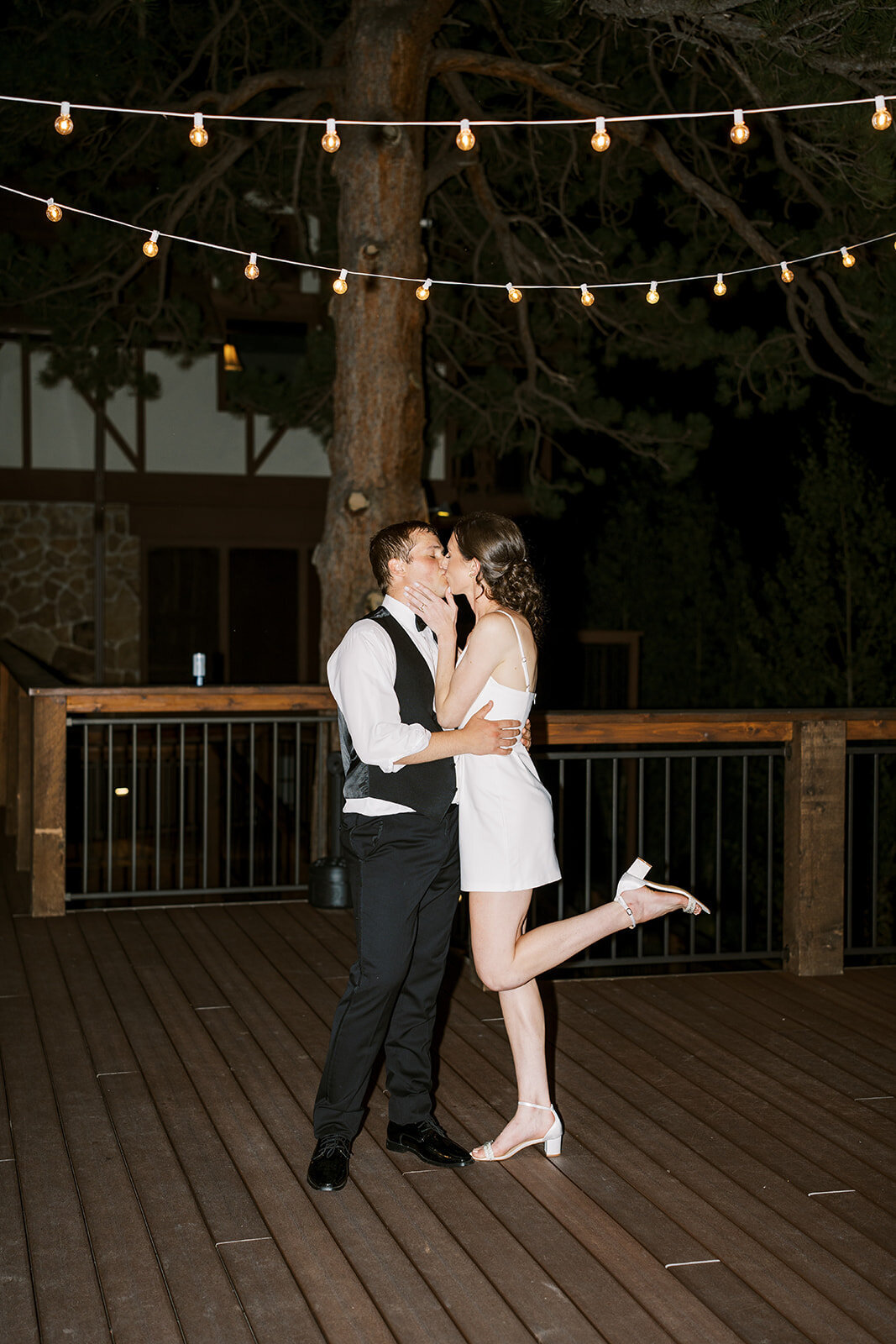 Bride and groom share a kiss at the Landing in Estes Park to wrap up their wedding night in their after party outfits.