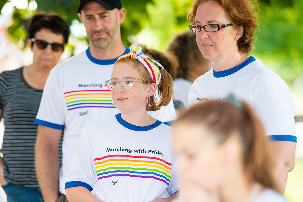a child with a pride t-shirt and handkerchief in her hair waiting for the Tweed Canopy Pride Parade to start.  Captured by Ottawa Event Photographer JEMMAN Photography COMMERCIAL