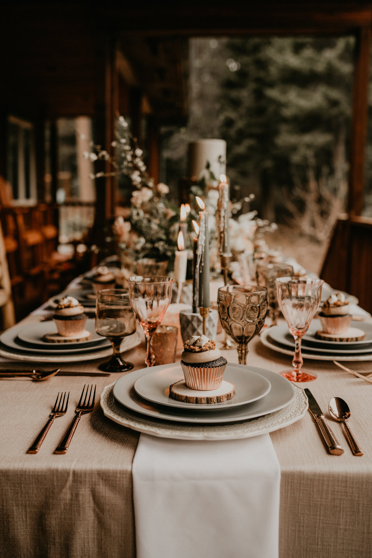 Elopement dinner table on cabin porch set with wildflowers, grey ceramic plates, pink & smoke glassware + s'mores cupcakes at each place setting!