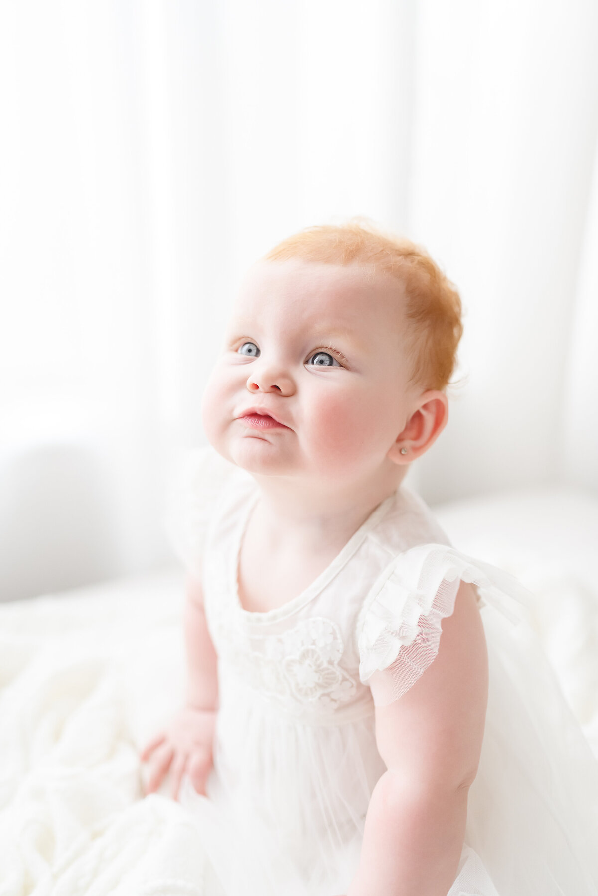 Baby and child photographer in Chandler, AZ baby girl with blue eyes and red hair smiling