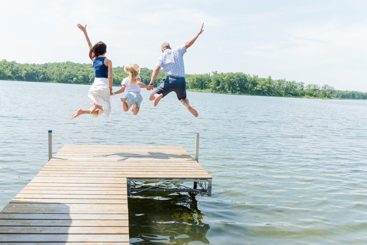 Family of Three Jumping off a dock during a Minnesota Summer Family Session