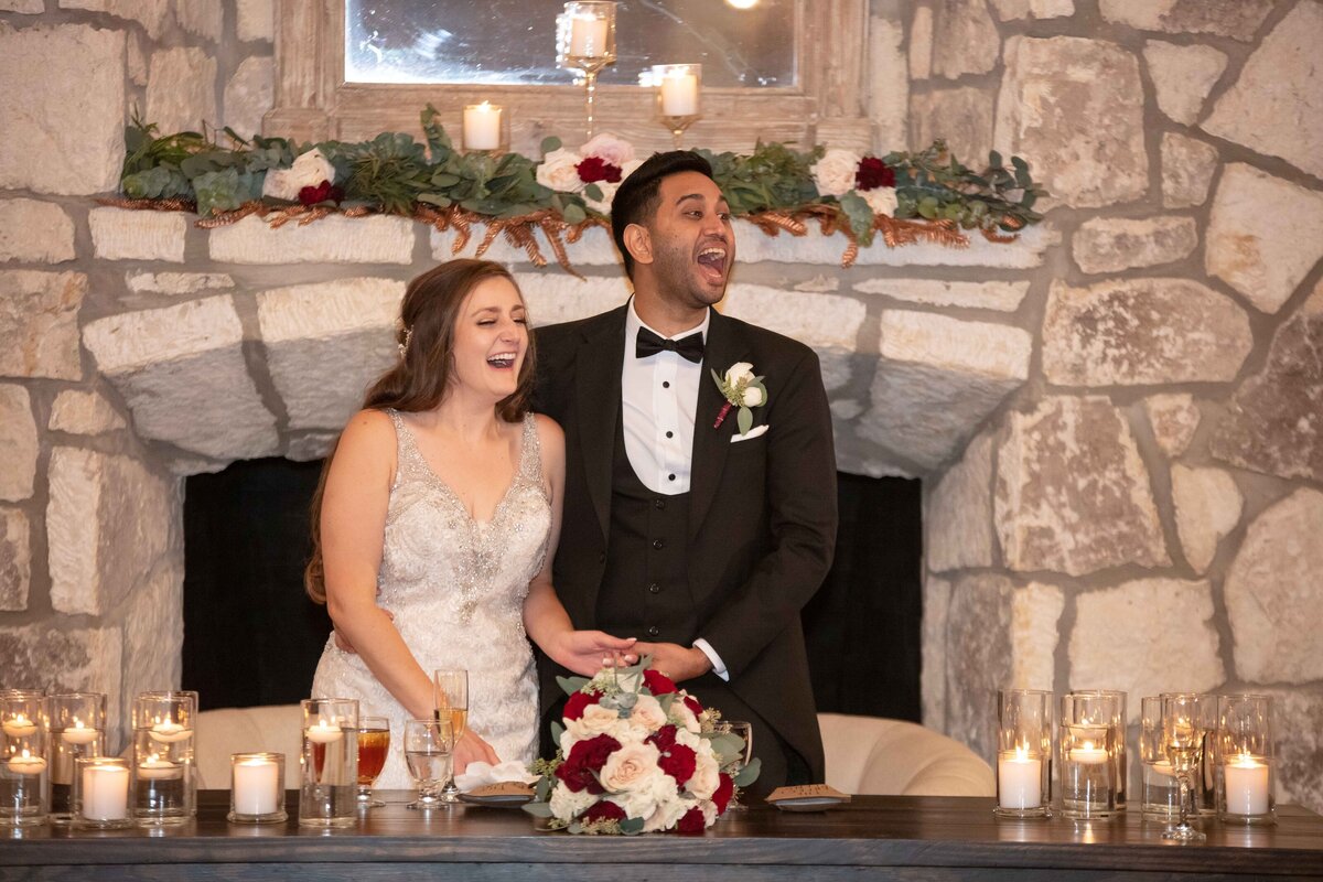 bride and groom laugh at toast among candles at Sendera Springs in Kerrville Texas