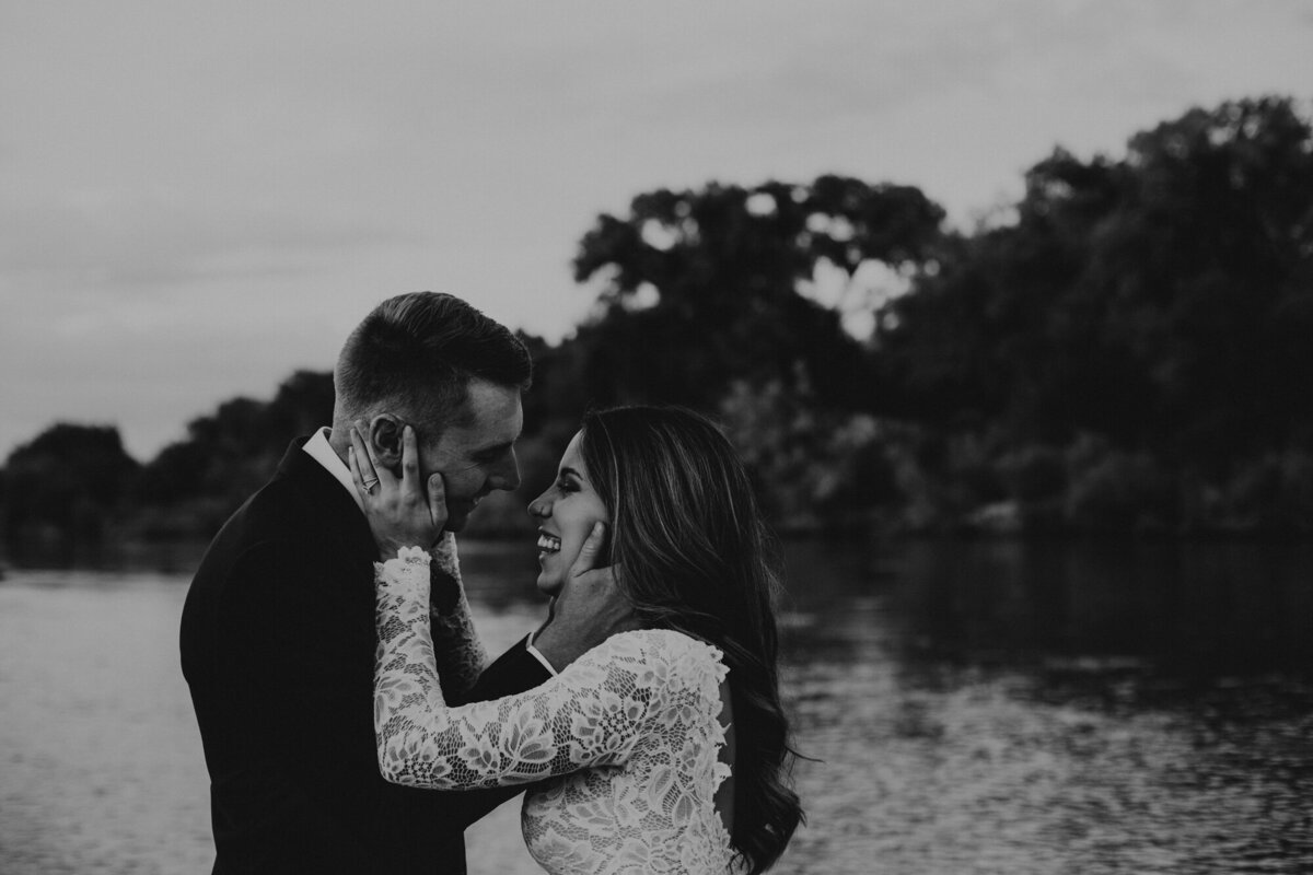 newlyweds holding each other by river