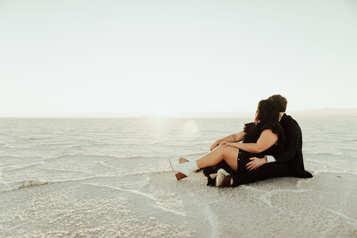 Couple sitting and cuddling together in the sand