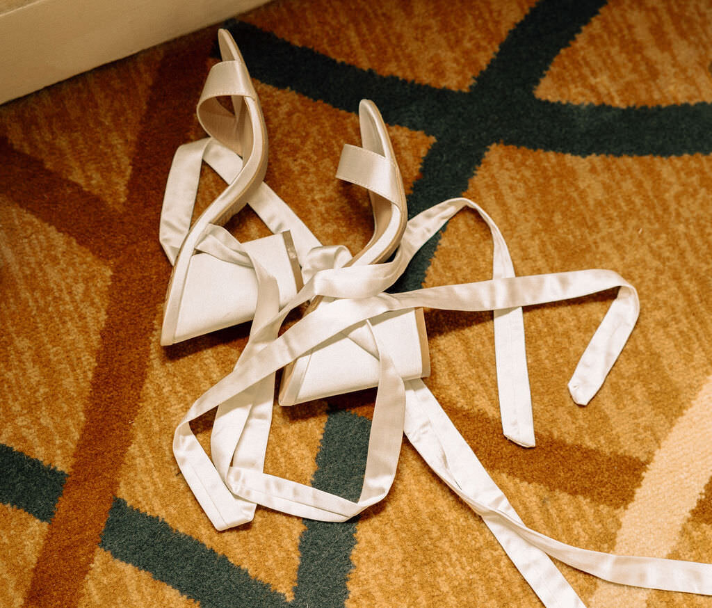 White heels laying on a carpet.