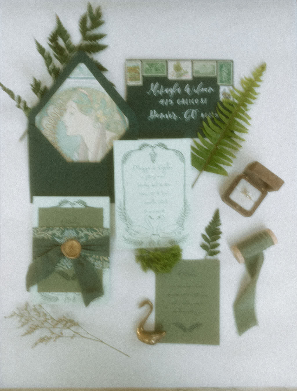 Wedding invitations and floral clippings laid out on a table.