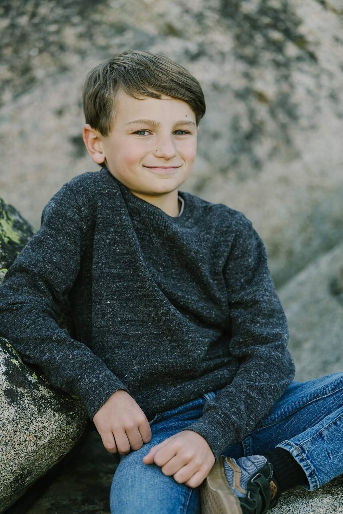 young boy smirking at camera during fall family session on donner summit