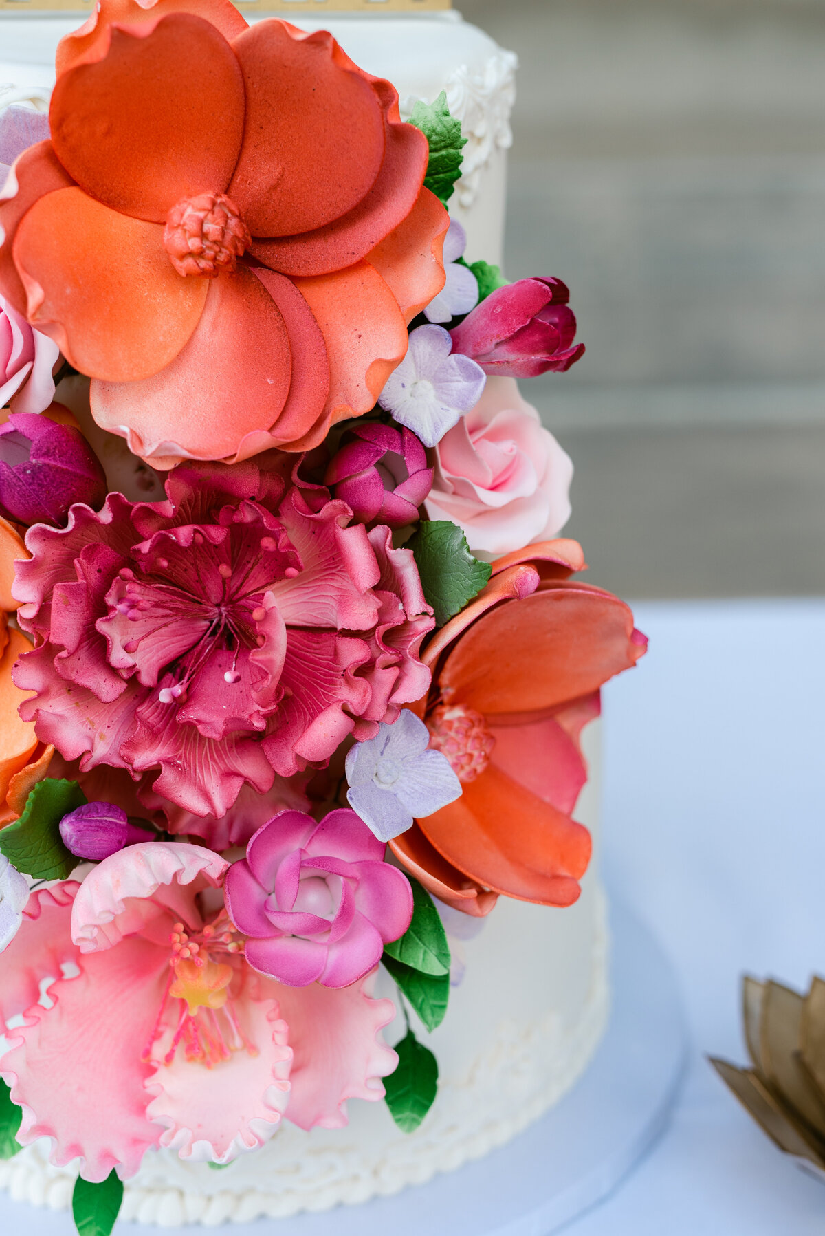 Real icing flowers on this orange and pink summer wedding cake.